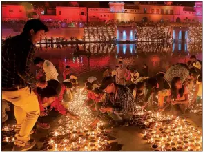  ?? AP/RAJESH KUMAR SINGH ?? Devotees light earthen lamps on the banks of the River Sarayu as part of Diwali celebratio­ns in Ayodhya, India, on Tuesday.