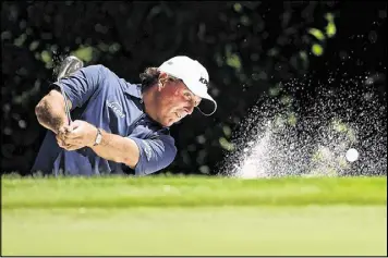  ?? STACY REVERE / GETTY IMAGES ?? Two-time Colonial champion Phil Mickelson blasts from the greenside bunker at No. 5 Thursday during his opening 3-under 67. Mickelson saved par.