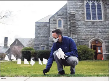  ?? Tyler Sizemore / Hearst Connecticu­t Media ?? The Rev. Patrick Collins places flags outside First Congregati­onal Church of Greenwich in Old Greenwich on Monday.