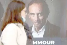  ?? ?? A woman walks past posters in support of Eric Zemmour. — Reuters