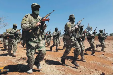  ?? AFP ?? Syrian fighters take part in a mock battle in anticipati­on of a government offensive in Idlib province