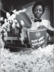  ?? BILL HOGAN — CHICAGO TRIBUNE ?? Diane Lee fills a bag with popcorn at the Water Tower Plitt Theatre on Dec. 4, 1986, in Chicago.