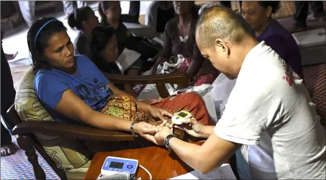  ??  ?? A woman undergoes medical check-up at a longhouse as others wait for their turn. ‘Wise ladies, they are.’ — Bernama file photo