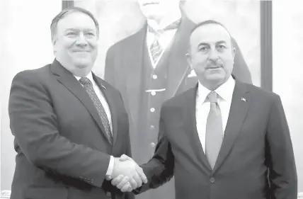  ?? ASSOCIATED PRESS ?? Turkey's Foreign Minister Mevlut Cavusoglu, right, and U.S. Secretary of State Mike Pompeo shake hands before a meeting at the Esenboga Airport in Ankara.