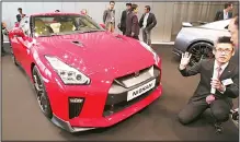  ??  ?? A visitor is briefed near a new 2017 Nissan GT-R model unveiled by the Nissan Motor Co at its global headquarte­rs gallery in Yokohama, near
Tokyo, April 1. (AP)
