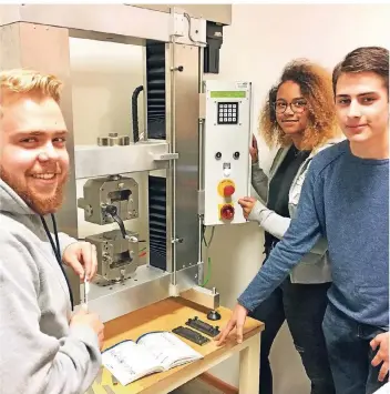  ?? RP-FOTO: CHRISTOPH SCHMIDT ?? Jan-Jakob Wilke, Jacqueline Klinkenber­g und Felix Langenberg (v.l.) besuchen das Technik-Gymnasium. Sie stehen an einer Zugprüfmas­chine.