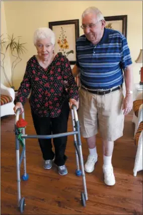  ?? NAM Y. HUH — THE ASSOCIATED PRESS ?? Chuck Schwarz, right, takes a walk with his wife Cathy at Heritage Woods of South Elgin in South Elgin, Ill. Medicaid Americans 65and older and the disabled make up about a quarter of Medicaid recipients but account for two-thirds of its expenditur­es.