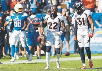  ?? Joe Amon, The Denver Post ?? Broncos defensive backs Kareem Jackson (22) and Justin Simmons celebrate stopping the Chargers’ Austin Ekeler on the final play of the first half Sunday.