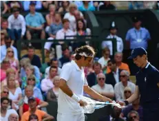  ??  ?? Below: with the assistance of a ball boy, Federer unwraps a fresh racquet during the men’s singles final — which he lost to Novak Djokovic — at Wimbledon, 2014