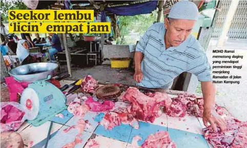  ??  ?? MOHD Ramzi memotong daging yang mendapat permintaan tinggi menjelang Ramadan di Jalan Hutan Kampung.