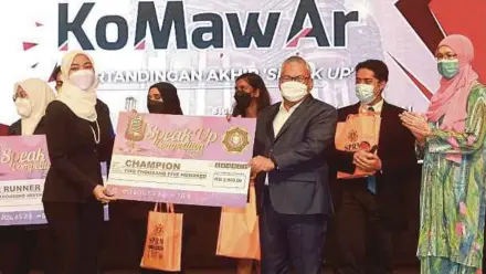  ?? (Foto Fathil Asri/bh) ?? Norazlan menyampaik­an hadiah kepada juara pertanding­an Speak Up, Madiha Syahidah Mohd Rohani, sempena Konvensyen Mahasiswa Antirasuah di Universiti Malaya, kelmarin.