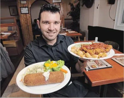  ?? PETER LEE WATERLOO REGION RECORD ?? Veslo Family Restaurant owner Aleksandar Culum holds plates of schnitzel inside the Kitchener restaurant. The schnitzel on the left is his Serbian signature schnitzel, and the one on the right is the Gypsy Schnitzel.