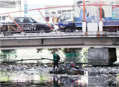  ?? ALI VICOY Y ?? TRAFFIC AT BASURA Sa ibabaw ng masikip na daloy ng trapiko, abala sa pagwawalis ang lalaki sa ilalim ng Juan Luna a Bridge sa Maynila, kahapon.