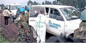  ?? — AFP photo ?? A medical vehicle of the North Kivu hospital is loaded with the body of the driver on a road on the edge of the Virunga National Park near the village of Kibumba, where Attanasio, his bodyguard and driver, were killed.