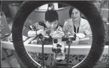  ?? LYU MING / CHINA NEWS SERVICE ?? Center: Workers at a food street in Fuzhou, Fujian province, promote local dishes online.