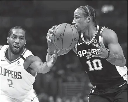  ?? Wally Skalij Los Angeles Times ?? KAWHI LEONARD, knocking the ball away from the Spurs’ DeMar DeRozan, was active on defense against his old team.