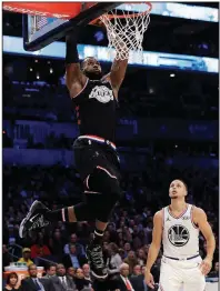  ?? AP/ CHUCK BURTON ?? LeBron James dunks against Stephen Curry in Sunday’s NBA All- Star Game. Team LeBron defeated Team Giannis 178- 164.