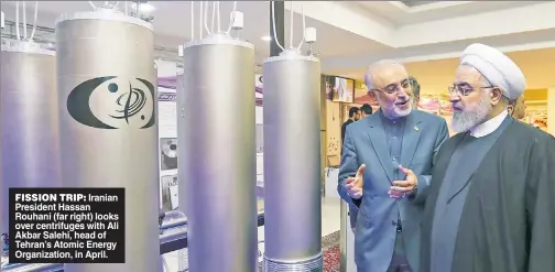  ??  ?? FISSION TRIP: Iranian President Hassan Rouhani (far right) looks over centrifuge­s with Ali Akbar Salehi, head of Tehran’s Atomic Energy Organizati­on, in April.