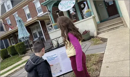  ?? PHOTO COURTESY OF COLL’S CUSTOM FRAMING ?? Nora Coll and little brother Rocco, study one of Conshohock­en Free Library’s Pop-up Poetry installati­ons at the borough’s ‘feine coffee shop, 812 Fayette St.