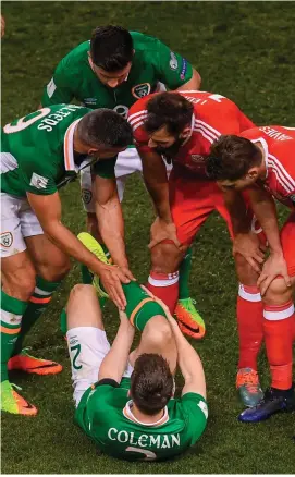  ?? STEPHEN McCARTHY/SPORTSFILE ?? Jon Walters, Shane Long, along with Wales’ pair Joe Ledley and Ben Davies attend to the injured Seamus Coleman on Friday