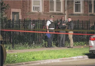  ?? | ASHLEE REZIN/ SUN- TIMES ?? Chicago Police investigat­e in the 8100 block of South Maryland after an officer was shot in the hand and the suspect was also wounded by the officer’s partner late Saturday.