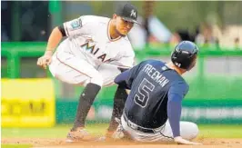  ?? MICHAEL REAVES/GETTY IMAGES ?? Miguel Rojas of the Miami Marlins tags out Freddie Freeman of the Atlanta Braves after he was picked off at first base during the first inning of Thursday’s game.