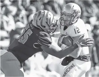  ?? AP PHOTO/MARK WEBER ?? Memphis linebacker Bryce Huff, left, sacks Tulsa quarterbac­k Seth Boomer during Saturday’s American Athletic Conference matchup in Memphis. The host Tigers won 47-21 to reach six wins and bowl eligibilit­y.