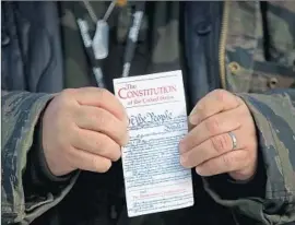  ?? Justin Sullivan
Getty I mages ?? A PROTESTER at an Oregon wildlife refuge holds a pocket copy of the U. S. Constituti­on annotated by late anti- communist conspiraci­st W. Cleon Skousen.