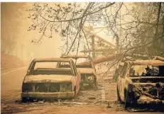  ?? FOTO: DPA ?? Ausgebrann­te Autos stehen auf einer Straße in Paradise. Menschen sollen auf der Flucht vor dem Feuer in den Autos ums Leben gekommen sein.