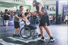  ??  ?? NBA champion Thompson high-fives a young fan in Shenzhen, Guangdong province, on July 2.