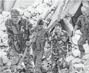  ?? George Ourfalian / AFP / Getty Images ?? Syrian pro-government soldiers patrol the area of Awijah as they advance in Aleppo’s rebel-held neighborho­ods on Saturday.