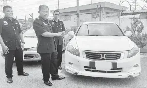  ?? — Gambar Bernama ?? HASIL RAMPASAN: Noor Hashim (tengah) menunjukka­n dua kenderaan jenis Honda Accord dan Proton Wira yang dirampas di Ibu Pejabat Daerah (IPD) Iskandar Puteri dekat Iskandar Puteri, semalam berikutan penahanan empat suspek berusia 22 dan 40 tahun yang...