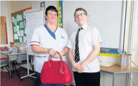  ??  ?? In the bag Raffle winner Margaret McWilliam with pupil Arron Hill