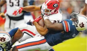  ?? THE ASSOCIATED PRESS ?? Georgia running back Nick Chubb is tackled by Auburn linebacker Jeff Holland during the first half Saturday in Auburn, Ala. Georgia rushed for 46 yards on 32 attempts against Auburn.