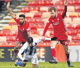  ??  ?? Kilmarnock’s Jordan Jones goes down under pressure from Shay Logan and Kari Arnason to win his side a penalty.