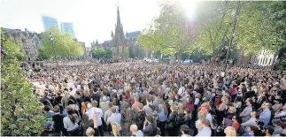  ??  ?? > Thousands gather for a vigil outside Manchester Town Hall last night