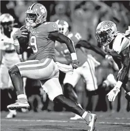  ?? MIKE COMER/GETTY ?? Travis Etienne runs for a score during Clemson’s 52-14 season-opening victory over Georgia Tech on Thursday night.