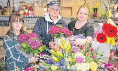  ?? SALLY COLE/THE GUARDIAN ?? Staff members Mary Langille, left, and Mary-Kate Stuart load George Maker up with flowers to be delivered at Hearts and Flowers in Charlottet­own. The Easter weekend means extra work for some people and less for others.