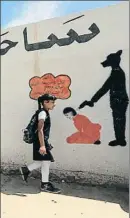 ?? ARI JALAL / REUTERS ?? Mosul. Una niña iraquí pasa ante un mural del EI