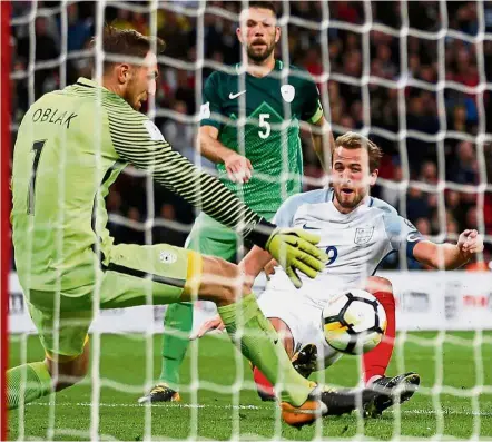  ?? — AFP ?? The saviour: England striker Harry Kane (right) scoring the only goal against Slovenia during the World Cup qualifier at Wembley on Thursday.