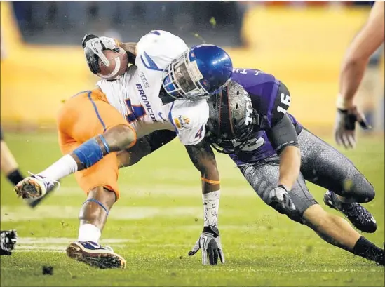  ?? Matt York Associated Press ?? TITUS YOUNG’S world-class speed and sure hands earned him a scholarshi­p to Boise State. Here he is stopped by TCU’s Jurell Thompson in the 2010 Fiesta Bowl.