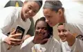  ?? PATRICK BREEN/THE REPUBLIC ?? ASU's Kiara Russell (left) video chats with her mom as teammates watch on Monday.