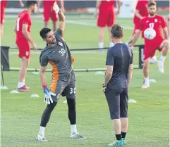  ?? ?? Iran goalkeeper Hossein Hosseini, left, stretches during training in Doha.