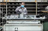  ?? THE NEW YORK TIMES ?? A worker performs tests on electronic components for elevators at the Schindler factory in Shanghai, China.