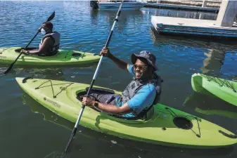  ?? Photos by Yalonda M. James / The Chronicle ?? Julius Crowe Hampton, an Outdoor Afro leader, kayaks with the group Saturday at Richmond’s Marina Bay Yacht Harbor. Below: Daria McKnight of Trackers Earth paddles along with them.