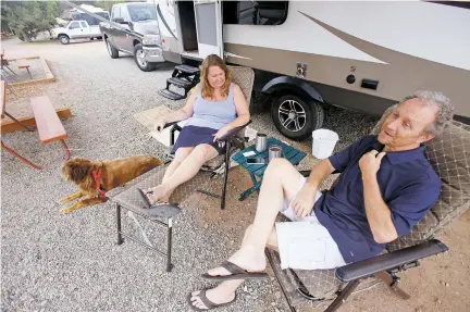  ?? LUIS SÁNCHEZ SATURNO/THE NEW MEXICAN ?? Angela Conk, left, and her husband, Joe Conk, both of Fort Worth, Texas, hang out at their campsite last week after arriving at the Santa Fe KOA Campground, 934 Old Las Vegas Highway.