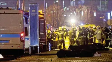  ?? Pictures: Reuters ?? Specialist­s gather near the covered bodies of killed people near the Crocus City Hall concert venue following the shooting incident, outside Moscow, Russia.