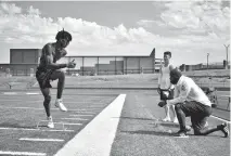  ?? [JAMES D. JACKSON/ THE OKLAHOMAN] ?? Choctaw senior defensive back and OU football commit Jordan Mukes, left, works on agility drills Thursday as assistant coach Tre Porter (kneeling) watches.