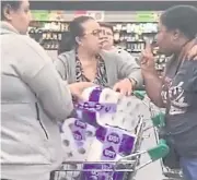  ??  ?? JUST ONE PACK!: Customers at a Sydney grocery store fight over the toilet paper rolls.