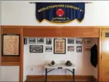  ?? LESLIE KROWCHENKO — DIGITAL FIRST MEDIA ?? Photos, newspaper clippings, helmets, patches and a uniform are among the Middletown Fire Co. items on display at Roosevelt School.